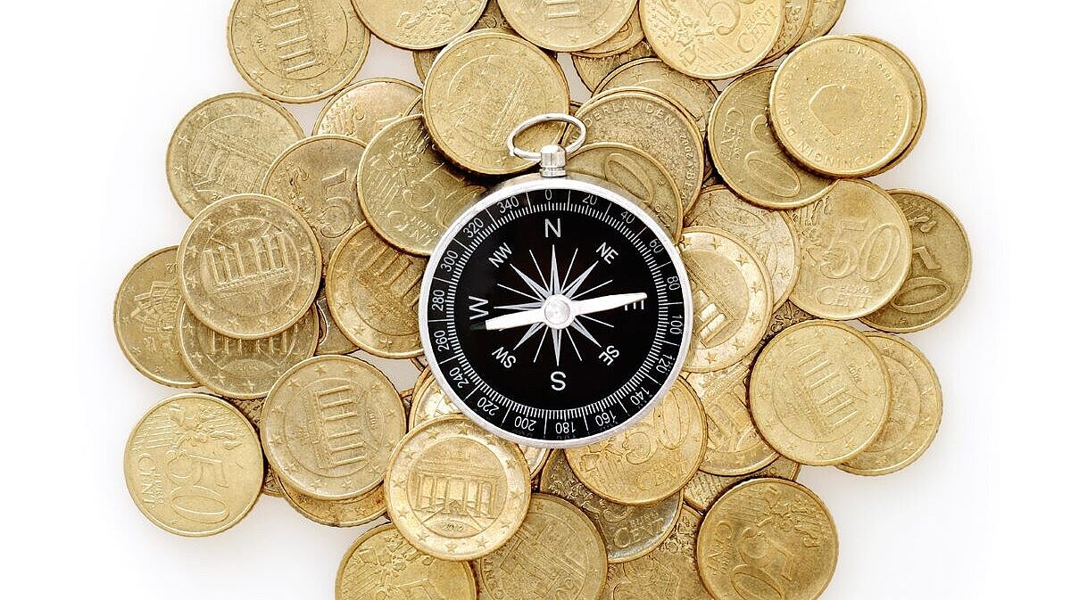 Foto Kompass liegt au Münzen