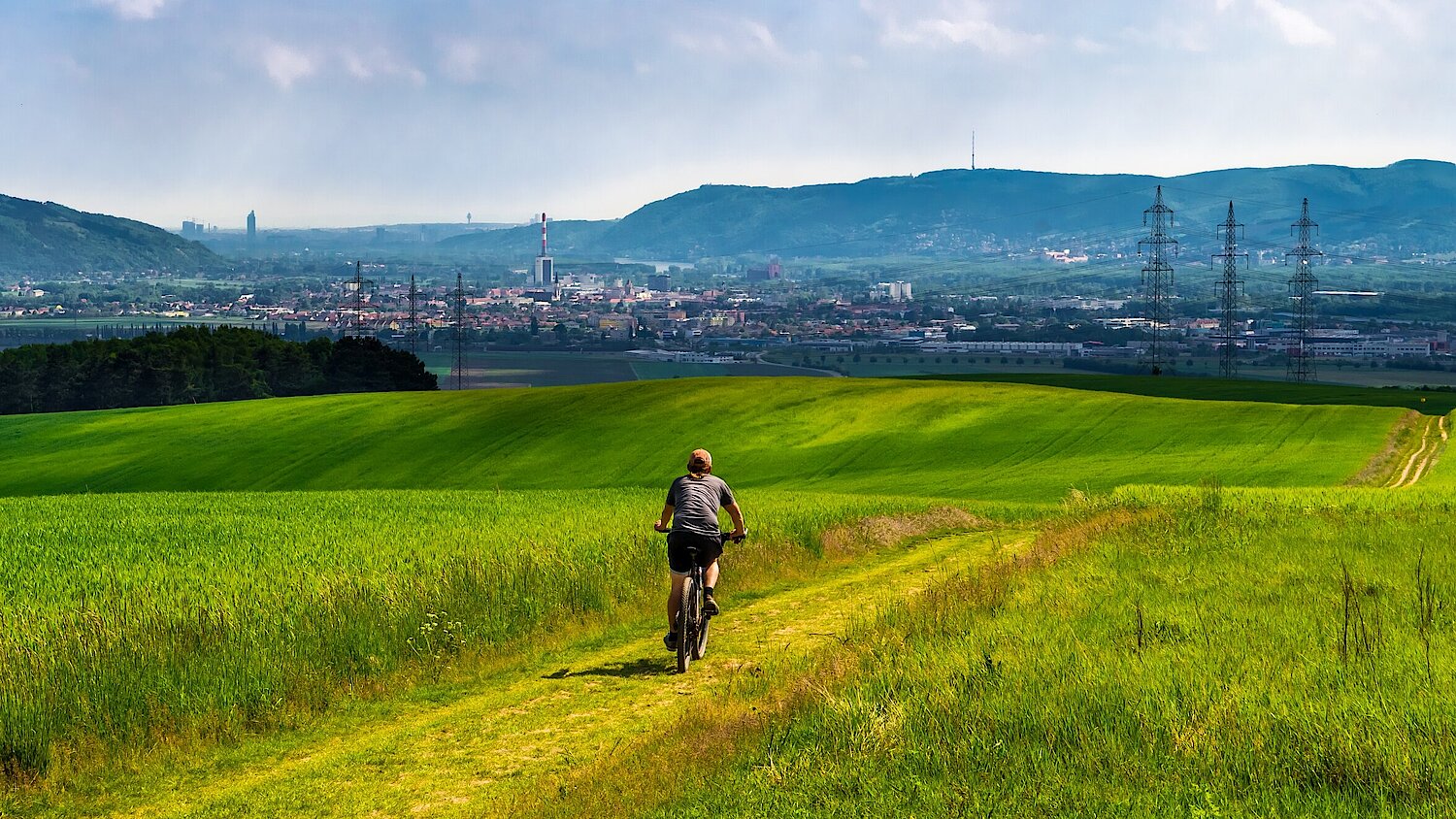 Foto Radfahrer auf Hügel vor einer Stadt